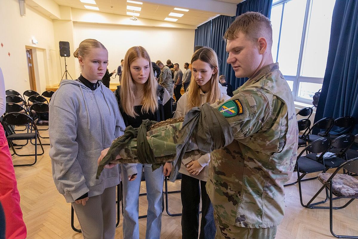 A soldier showing students how to splint a padded arm