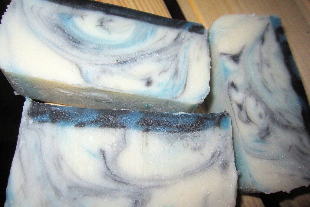 Bars of white homemade soap swirled with blue, cut and stacked